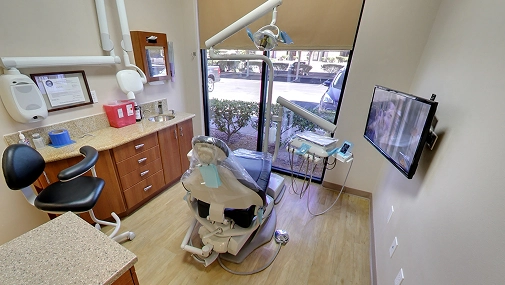 A clean and fully equipped dental treatment room at Ascend Dental Studio in Henderson NV featuring a dental chair overhead light and wall mounted monitor