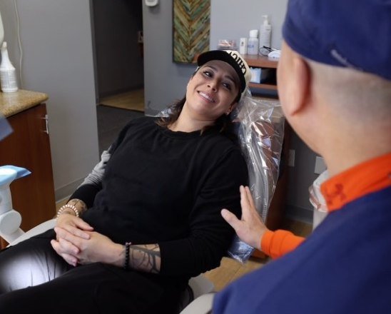 Patient smiling during consultation with dental staff member at Henderson dental practice.